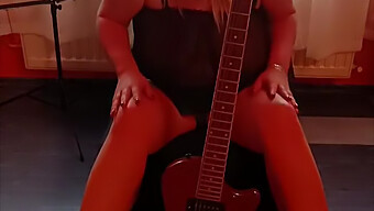 En Blond Milf Ägnar Sig Åt Solospel Med Sin Gitarr Och Underkläder.